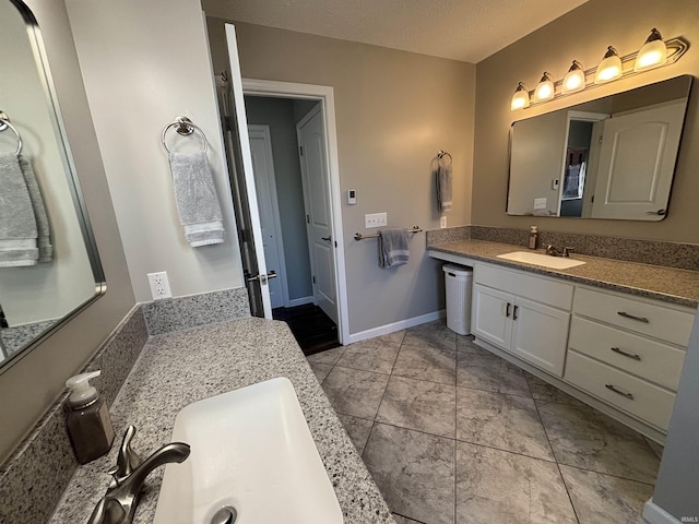 bathroom featuring tile patterned flooring, a textured ceiling, vanity, and baseboards