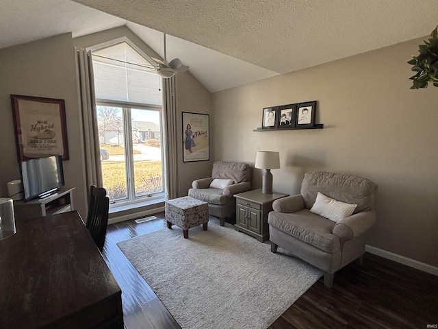 living area with visible vents, dark wood-type flooring, a textured ceiling, baseboards, and lofted ceiling