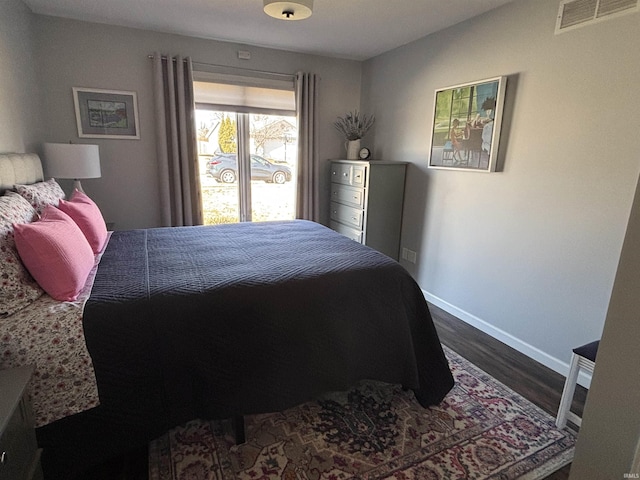 bedroom with dark wood finished floors, visible vents, and baseboards