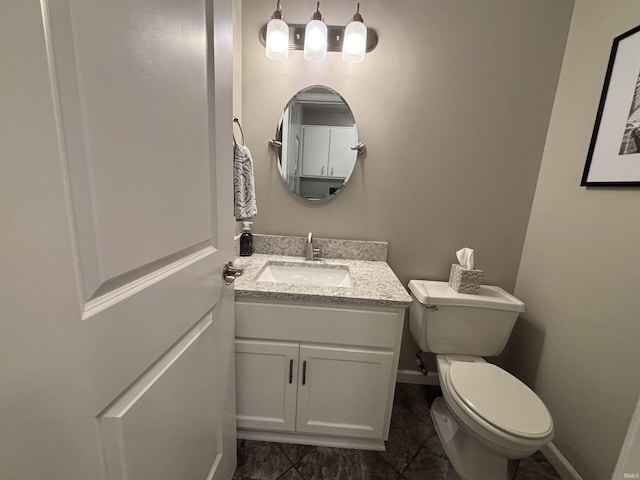 bathroom with baseboards, toilet, and vanity