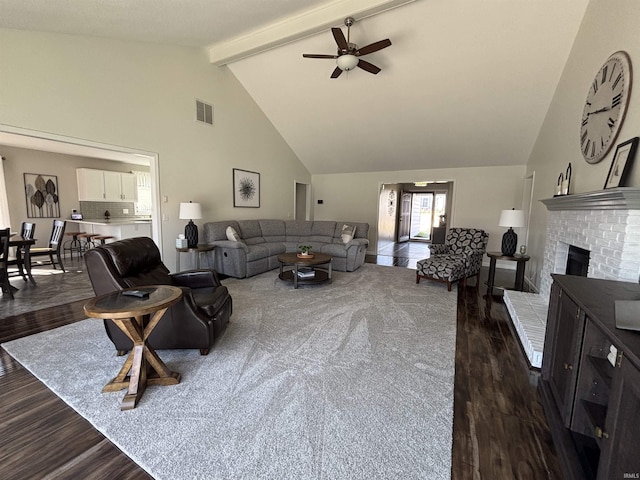 living room with visible vents, beamed ceiling, dark wood-style flooring, and a ceiling fan