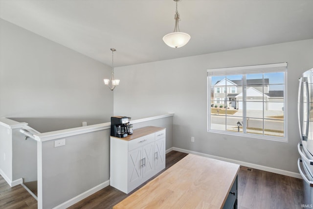 interior space with a notable chandelier, baseboards, and dark wood-type flooring