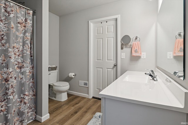 full bath with visible vents, baseboards, toilet, wood finished floors, and vanity