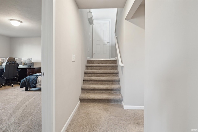 stairs featuring baseboards and carpet floors