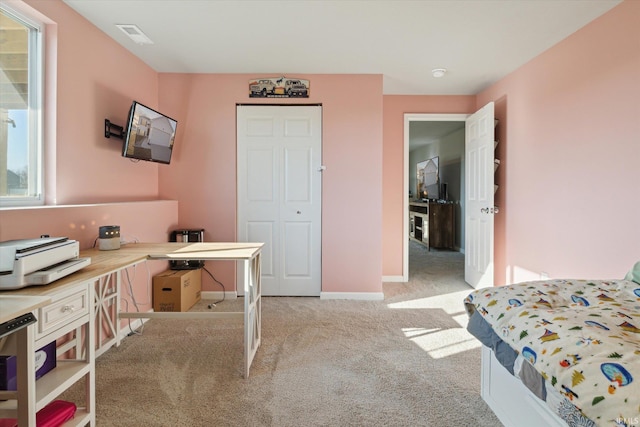 bedroom with light colored carpet and baseboards