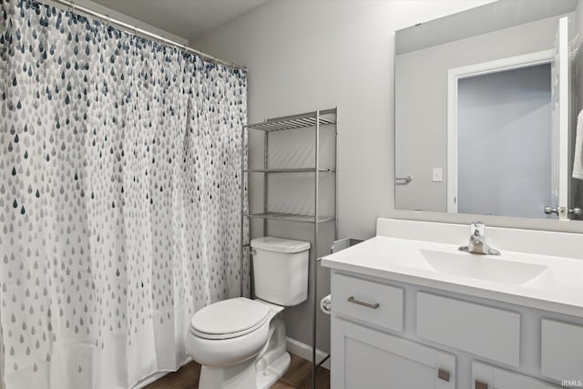 bathroom featuring curtained shower, toilet, vanity, and wood finished floors