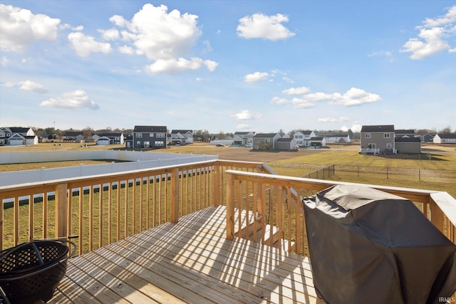 deck featuring grilling area, a residential view, a yard, and fence