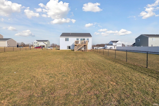 view of yard with a deck, stairs, and a fenced backyard