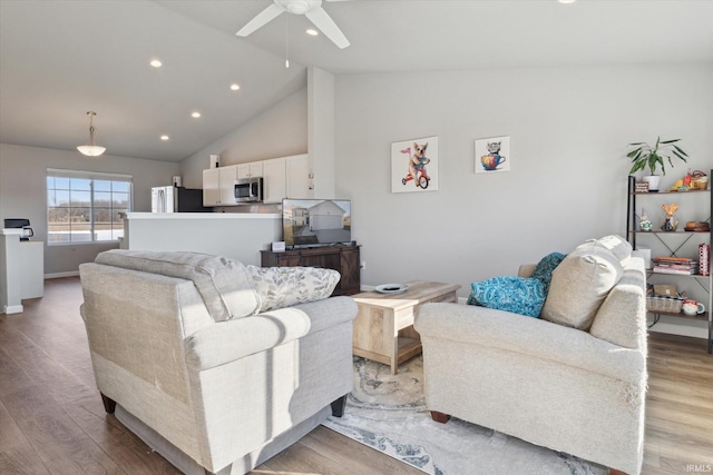 living area featuring baseboards, high vaulted ceiling, light wood-style flooring, recessed lighting, and ceiling fan