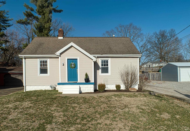 view of front of home with fence, roof with shingles, a chimney, a front lawn, and an outdoor structure