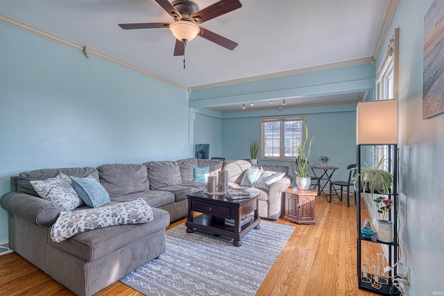 living room with a ceiling fan, light wood finished floors, and ornamental molding