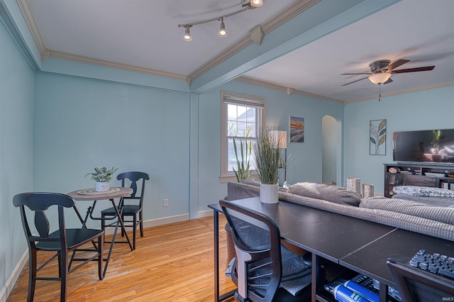 home office featuring arched walkways, ornamental molding, baseboards, and wood finished floors