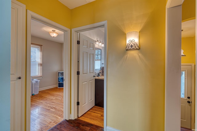 corridor with baseboards and dark wood-style flooring