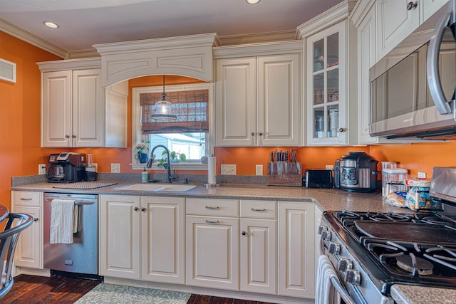 kitchen featuring a sink, recessed lighting, appliances with stainless steel finishes, crown molding, and glass insert cabinets