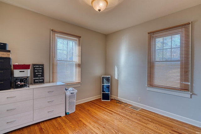 bedroom featuring light wood-type flooring, baseboards, and visible vents