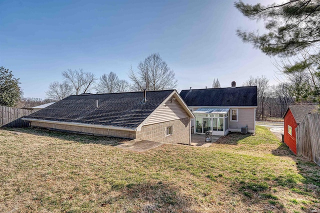 rear view of property featuring a patio area, a lawn, and fence