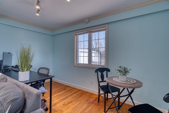 office featuring light wood finished floors, crown molding, and baseboards