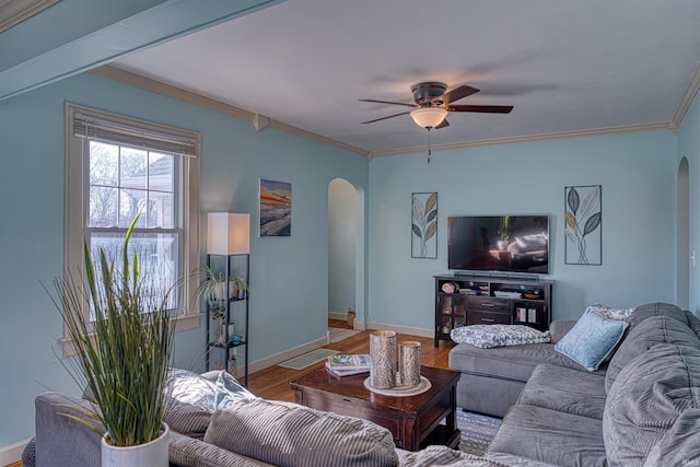 living room featuring arched walkways, crown molding, and wood finished floors