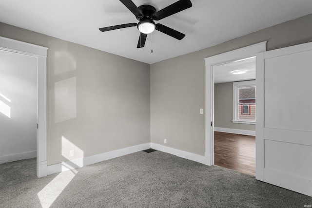 carpeted empty room with baseboards and a ceiling fan