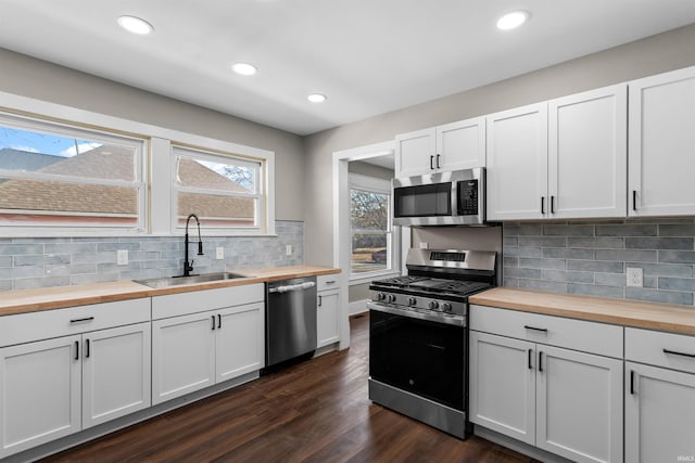 kitchen with a sink, stainless steel appliances, and butcher block countertops