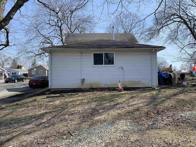 back of house featuring a shingled roof