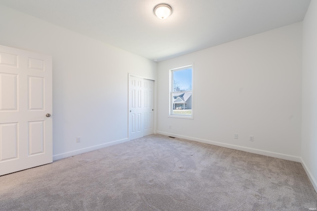 unfurnished bedroom featuring baseboards, carpet floors, and a closet