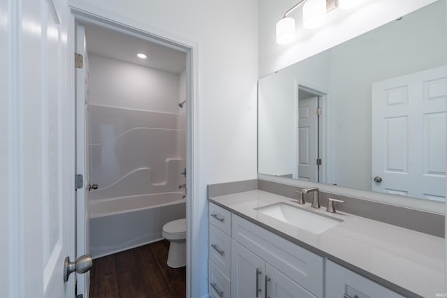 bathroom featuring vanity, toilet, wood finished floors, and shower / bath combination