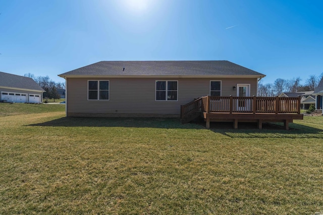 rear view of house featuring a lawn and a deck