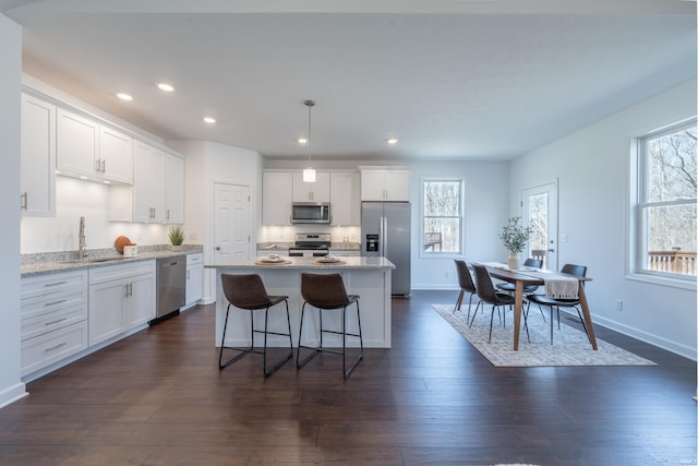 kitchen featuring dark wood finished floors, white cabinets, stainless steel appliances, and a sink