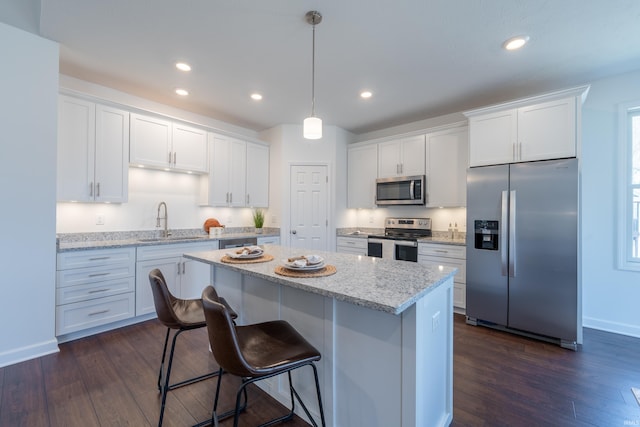 kitchen with white cabinetry, a kitchen island, appliances with stainless steel finishes, and a sink