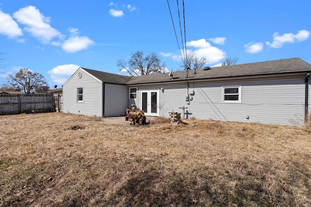 back of property featuring french doors, fence, and roof with shingles