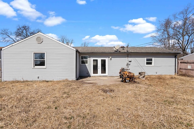 back of property featuring french doors, roof with shingles, and fence