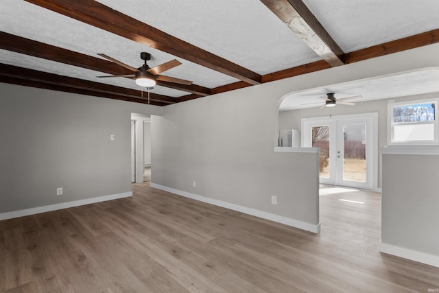 unfurnished room featuring a textured ceiling, baseboards, a ceiling fan, and wood finished floors