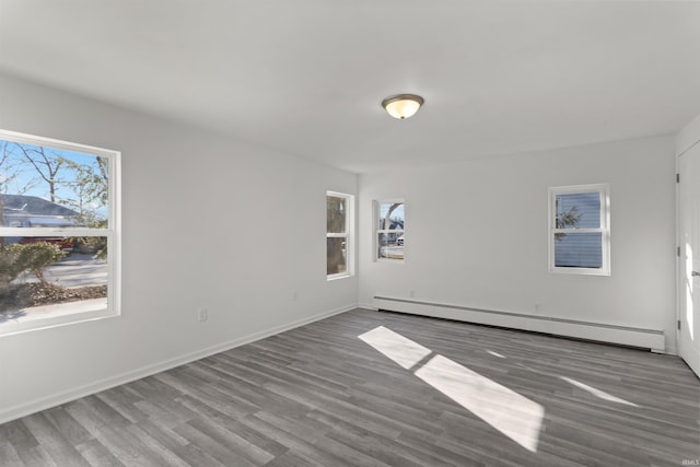 unfurnished room with wood finished floors, baseboards, and a baseboard radiator