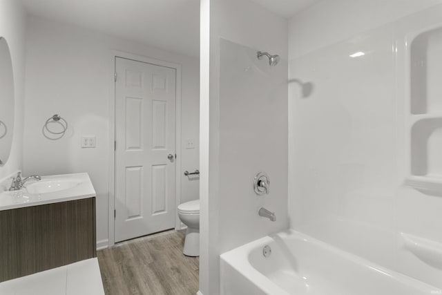 bathroom featuring shower / bathing tub combination, toilet, wood finished floors, and vanity