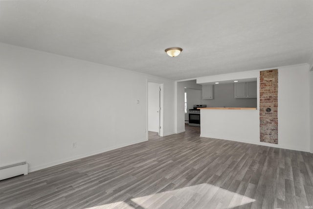 unfurnished living room featuring wood finished floors, baseboards, and a baseboard radiator