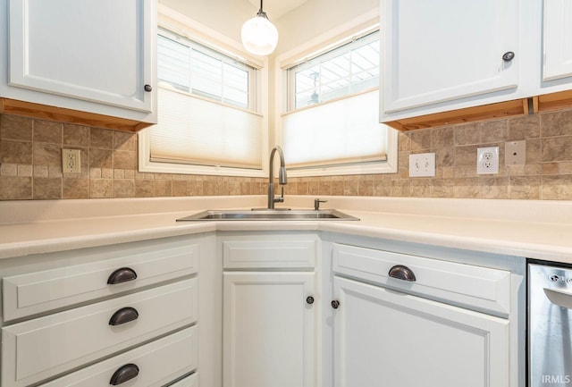 kitchen with decorative backsplash, white cabinetry, and a sink