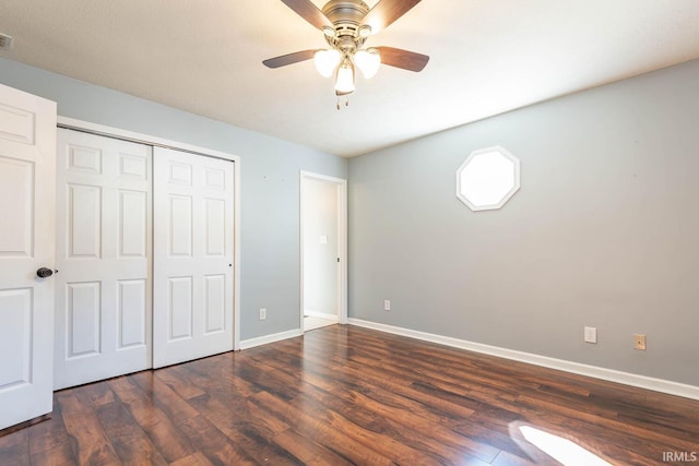 unfurnished bedroom with dark wood-style floors, a closet, baseboards, and a ceiling fan