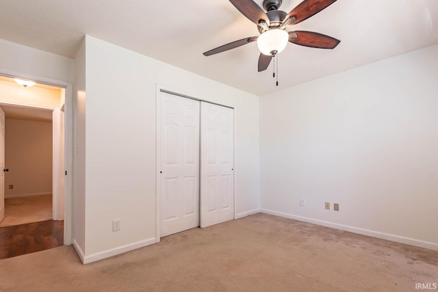 unfurnished bedroom with carpet flooring, baseboards, a closet, and ceiling fan