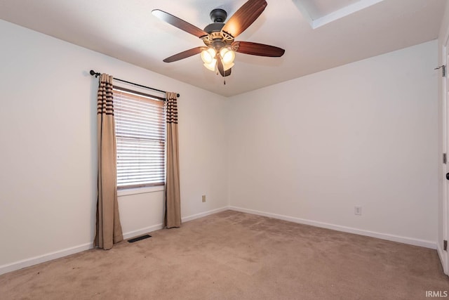 spare room with visible vents, baseboards, light colored carpet, and ceiling fan