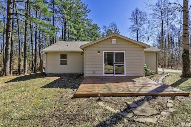 rear view of house with a wooden deck and a yard