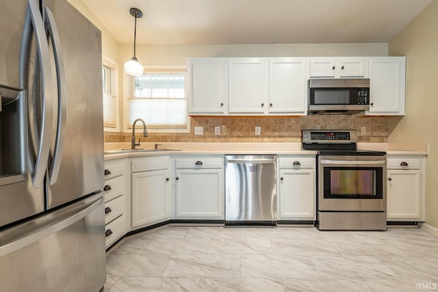 kitchen featuring marble finish floor, a sink, stainless steel appliances, white cabinets, and light countertops