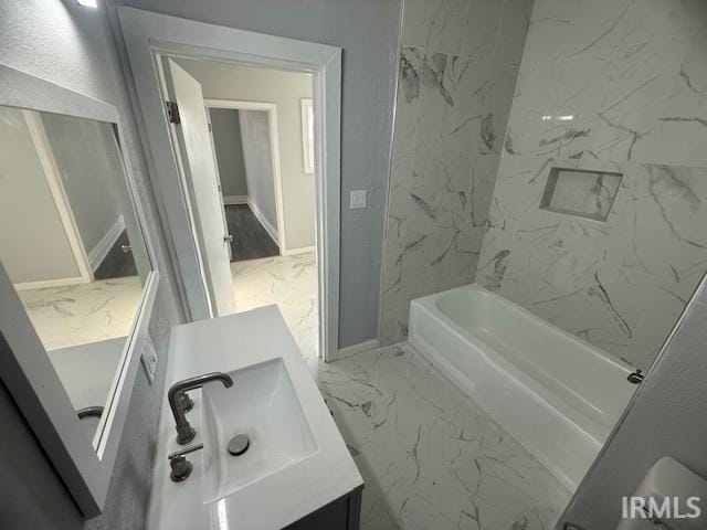 bathroom featuring vanity, baseboards, marble finish floor, and shower / bathtub combination