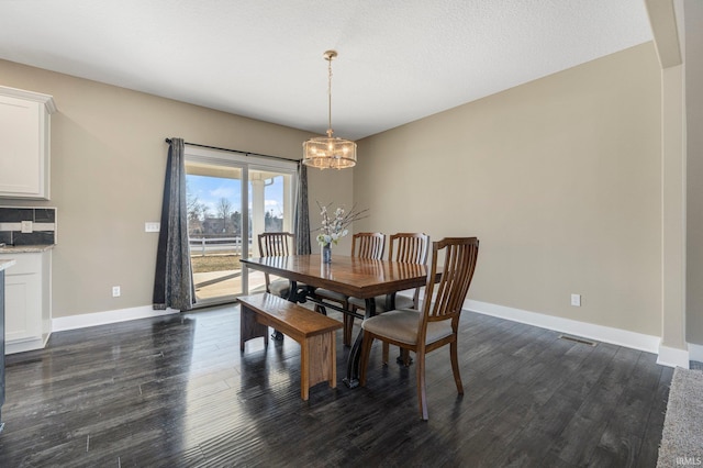 dining area with an inviting chandelier, dark wood-style floors, baseboards, and visible vents