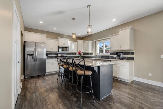 kitchen featuring dark wood finished floors, appliances with stainless steel finishes, and white cabinetry