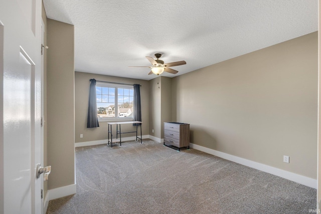 interior space with light carpet, ceiling fan, a textured ceiling, and baseboards