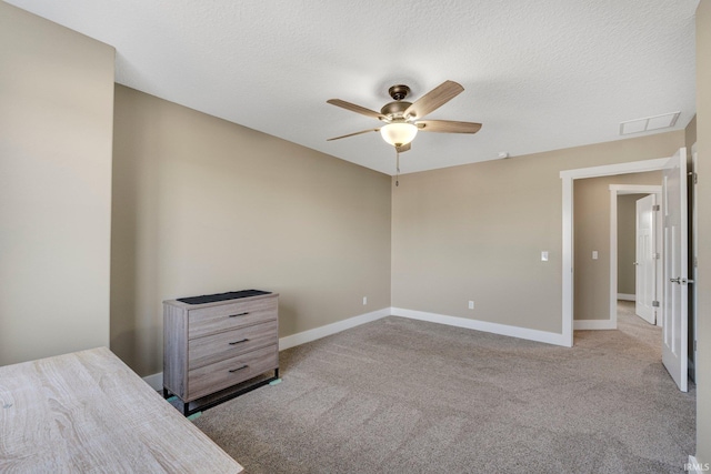 unfurnished bedroom featuring carpet flooring, baseboards, visible vents, and a textured ceiling