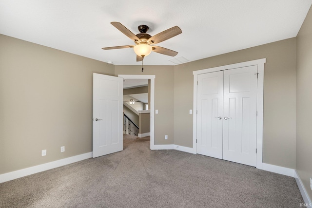 unfurnished bedroom featuring a closet, baseboards, light carpet, and a ceiling fan