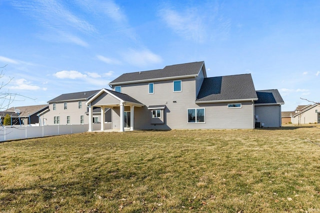 back of house featuring a yard and fence