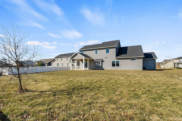 rear view of house with a yard and fence